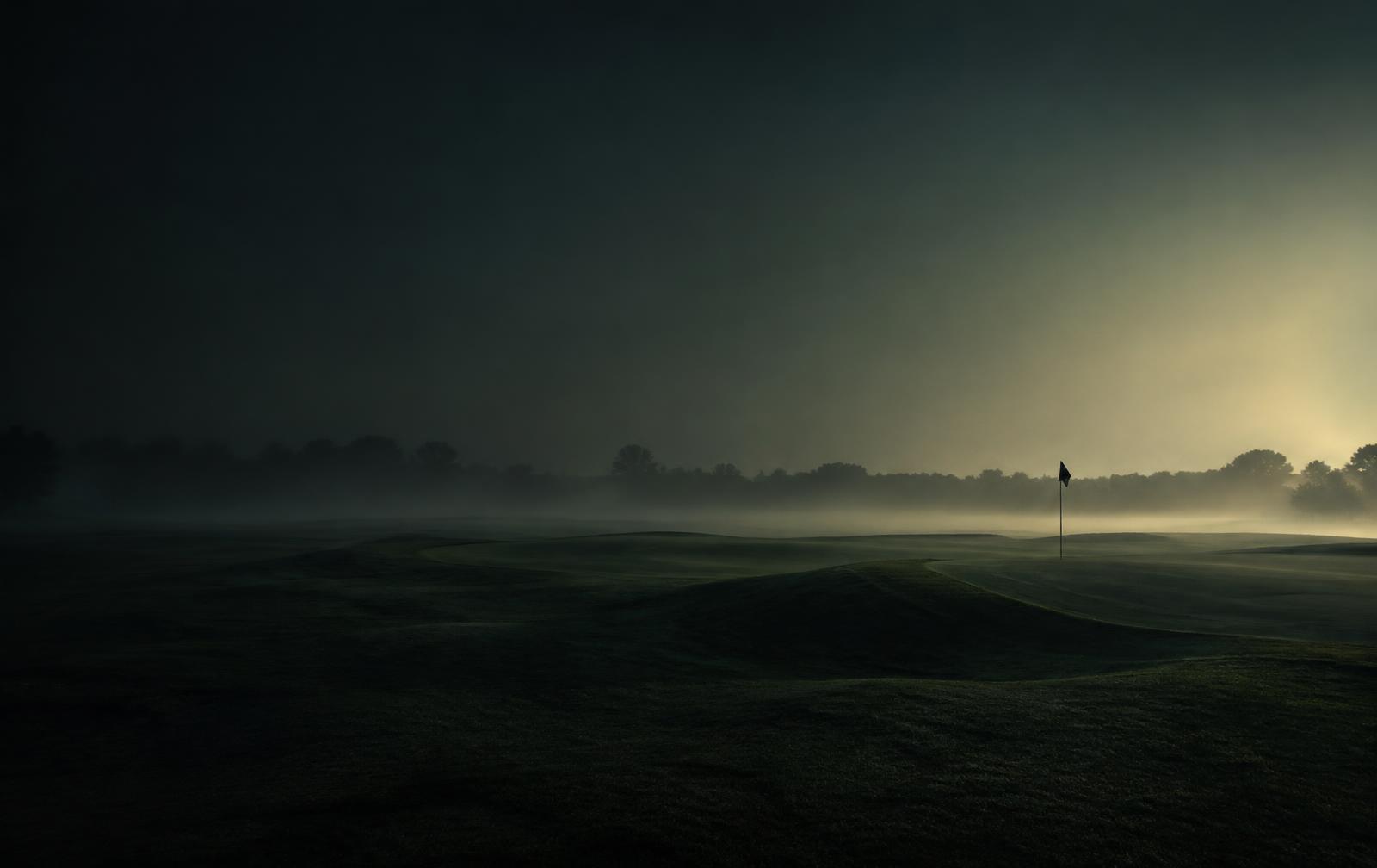 Dimmig golfbana i gryningsljus
